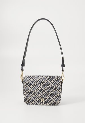 Borsa a mano in tessuto testurizzato beige con un motivo geometrico blu, dotata di tracolla in pelle nera e dettagli in metallo dorato.