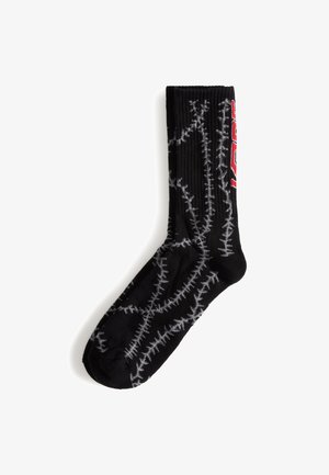 Black sock featuring a ribbed design, adorned with a gray barbed wire pattern and a bold red graphic on the side.