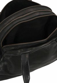 Zwarte leren tas met meerdere compartimenten en gouden ritsen. Soepele textuur, stevige handvatten en minimale ontwerpelementen.