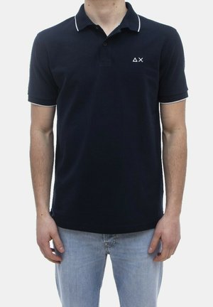 Polo blu navy con bottoni a due vie, colletto con accento bianco e logo sul petto. Maniche corte e texture in cotone liscia.