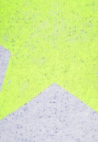 Textil con un vibrante fondo amarillo neón y una superficie texturizada, complementado por un destacado patrón geométrico gris.
