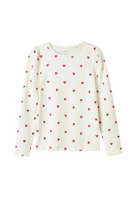 Haut à manches longues en coton écru avec un motif de cœurs rouges dispersés. Texture douce avec des coutures d'épaule froncées et un col rond.