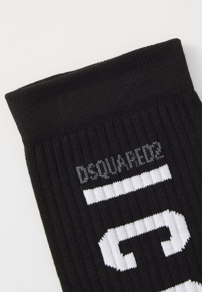 Calcetín negro de canalé con letras de punto blancas "DSQUARED2" y un gran número "5" estilizado en blanco en el lado.