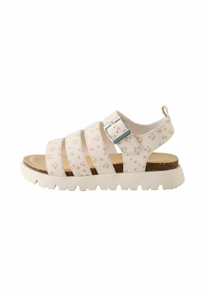 Hvid sandal med pink blomstermønster, tre remme, sølvspænde, korkindlægssål og tyk hvid ridsesål, sidevisning.