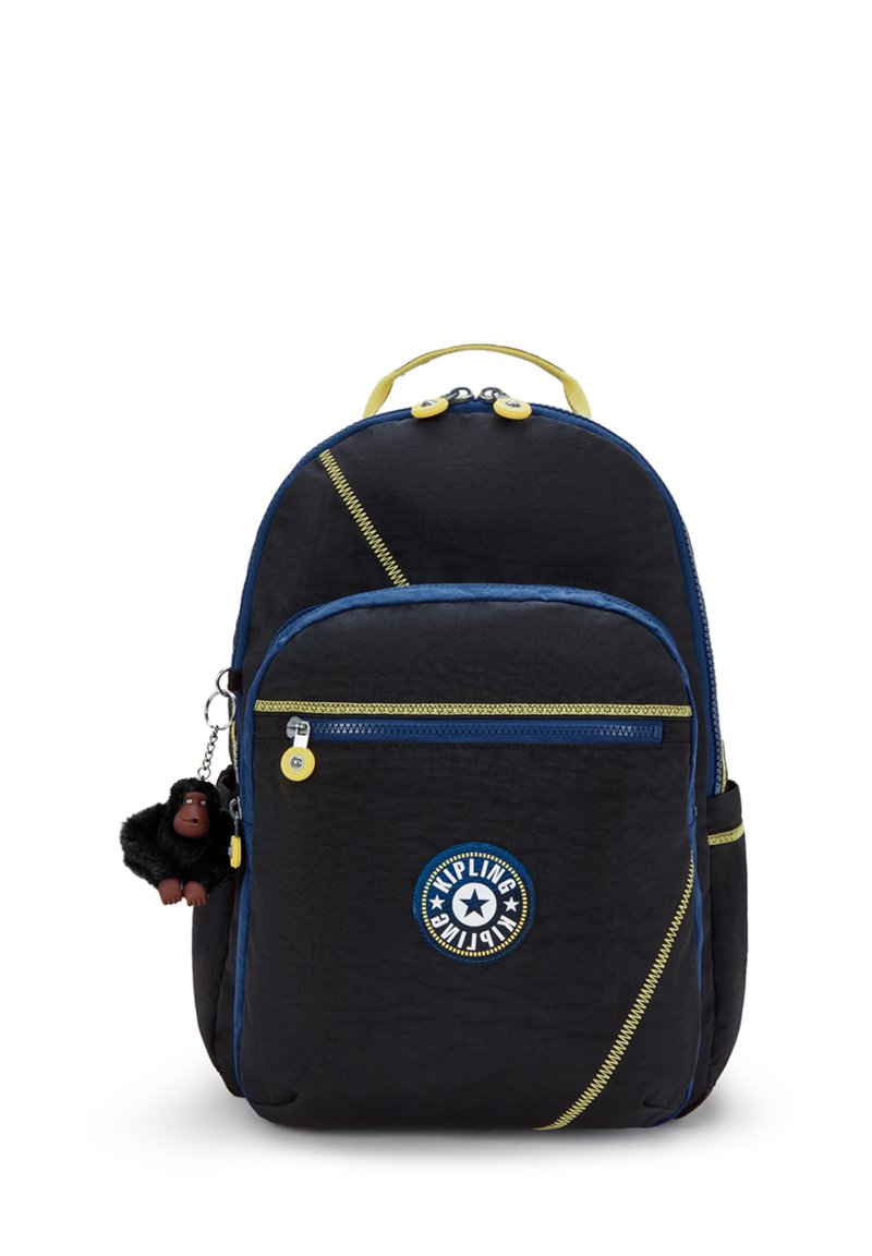 Zaino in nylon nero con accenti blu e gialli, forma curvata, tasca frontale con zip, finitura testurizzata e un portachiavi a forma di scimmia attaccato.