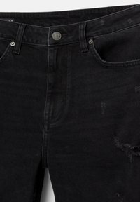 Des jeans en denim noir présentent un design déchiré avec des bords effilochés, un style à cinq poches et un bouton en métal à la taille pour la fermeture.