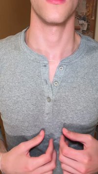 Harmaa ribbattu henley-paita, jossa on kolme nappia ja pyöreä kaula-aukko. Käsivarret ovat sijoitettu lähelle paidan alareunaa.