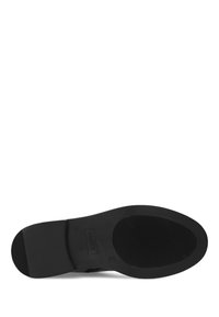 Czarna gumowa podeszwa buta z poziomymi i pionowymi wzorami teksturowymi, charakteryzująca się gładkim, zaokrąglonym kształtem. Widoczne logo marki.