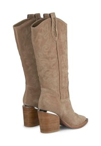 Botas de vaquera de ante en color taupe con costuras intrincadas. Presentan una punta puntiaguda y un tacón de madera apilada con un acento metálico.