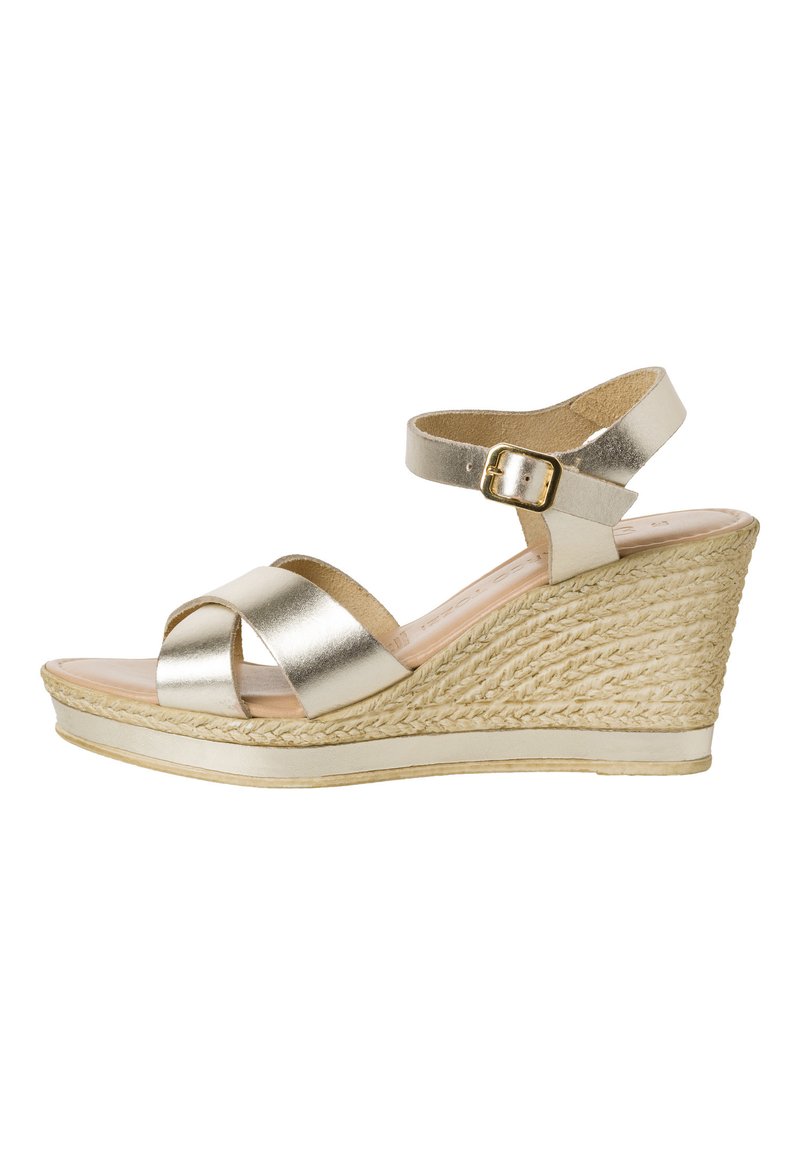 Sandalo a wedge in oro metallico con design a fascia incrociata, fibbia alla caviglia, suola in juta intrecciata e una soletta in tessuto liscio. Altezza di circa 8 cm.