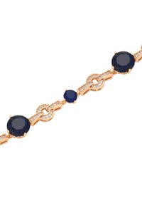 Bracciale color oro con pietre rotonde blu scure alternate e accenti simili a diamanti, collegato da forme geometriche, che mostra un design elegante.