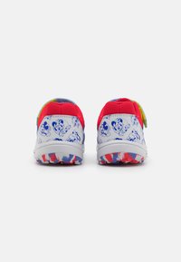 Red and white athletic shoes with a blue patterned back, featuring cartoon graphics and colorful accents on the tongue and sole.