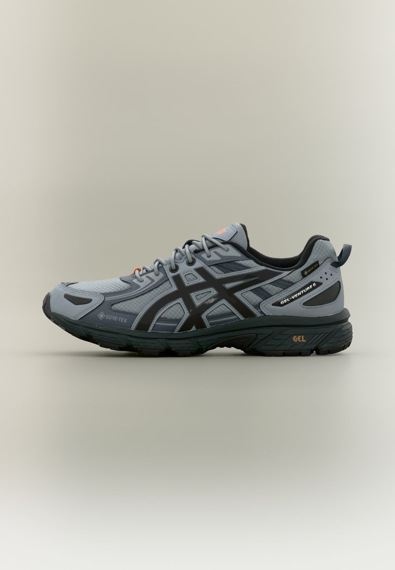 Γκρι και μαύρο αθλητικό παπούτσι Asics Gel-Venture 6 με επάνω μέρος από Gore-Tex και μαύρη σόλα, πλευρική όψη σε ουδέτερο φόντο.
