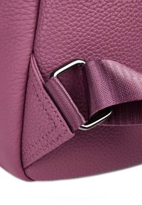 Coin de sac en cuir violet à pois avec une boucle en métal argenté et une bandoulière en satin texturé. Détails de couture visibles et bords lisses.