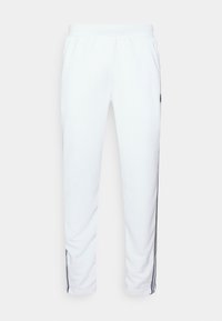 Bílé jogger kalhoty s elastickým pasem, bočními kapsami a kontrastními černými pruhy po stranách. Měkká textura látky.