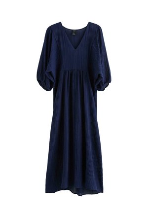 Marineblå plisseret kjole med dyb V-udskæring og ballonærmer. Stoffet har en tekstureret overflade og falder til midt på læggen.