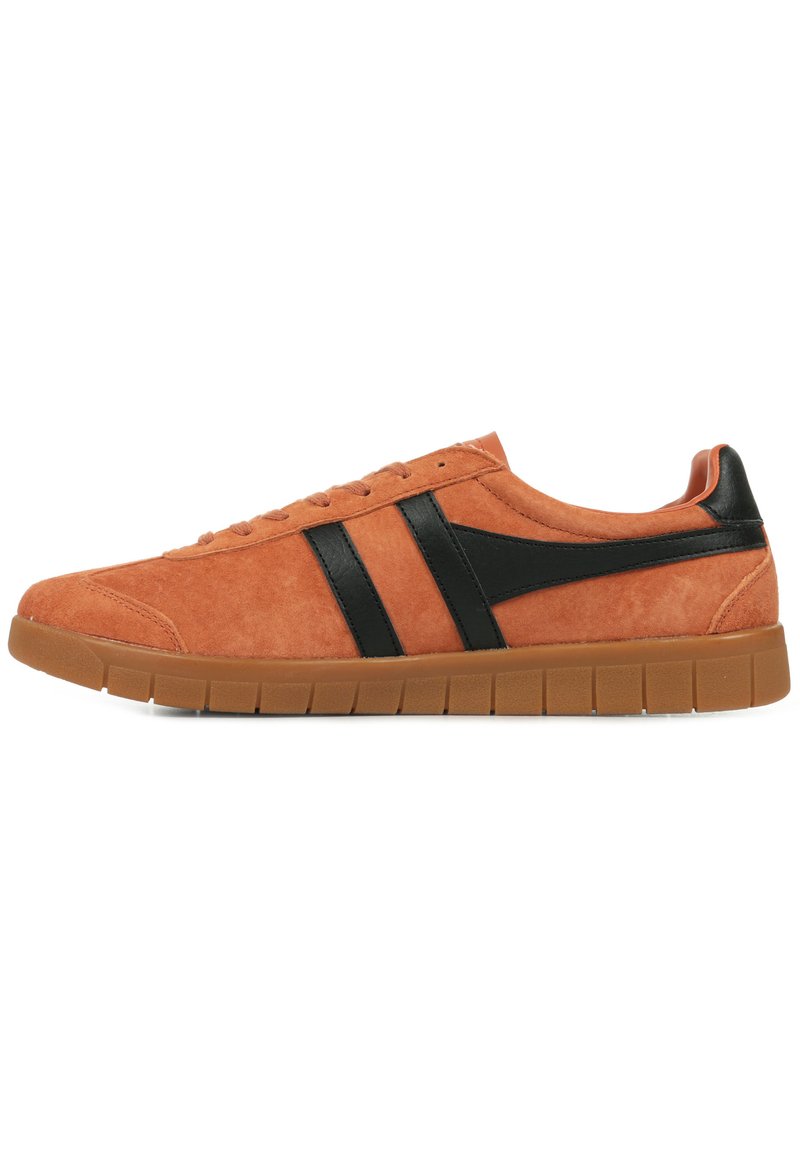 Sneaker in suede arancione con dettagli in pelle nera, caratterizzato da una punta arrotondata, suola piatta e design con lacci. Superficie testurizzata e dettagli minimi.