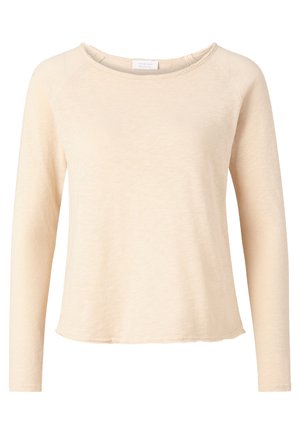 Bež majica s dugim rukavima, izrađena od mekog materijala, s okruglim izrezom i zakrivljenim rubom, koja ima blago teksturirani materijal i raglan rukave.