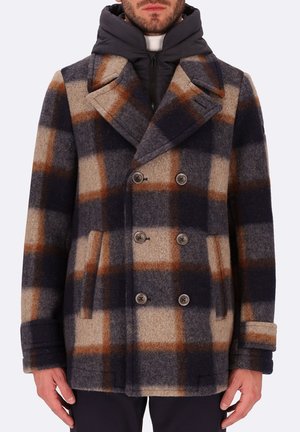 Cappotto a doppio petto in misto lana nei colori blu navy, beige e marrone a quadri. Presenta grandi revers, dettagli con bottoni e tasche laterali. Collo interno imbottito.