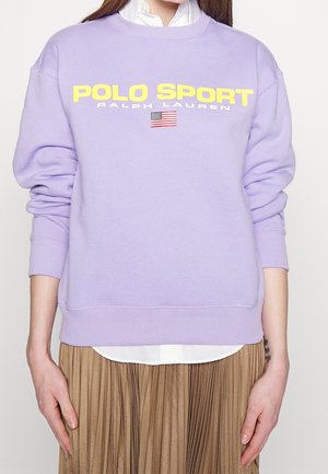 Fioletowy sweatshirt z prążkowanymi mankietami i dołem. Posiada wyraźny żółty napis "POLO SPORT" oraz małą grafikę amerykańskiej flagi.