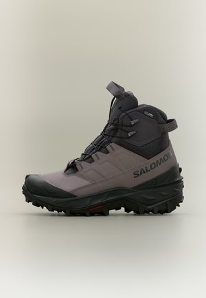 Chaussure de randonnée Salomon montante en violet sourd et noir avec une semelle robuste et un système de laçage rapide, conçue pour une utilisation extérieure.