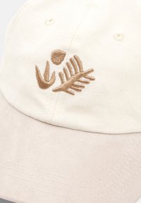 Beige cotton cap with a soft, textured visor. Features embroidered brown leaf and petal designs on the front. Classic, adjustable design.