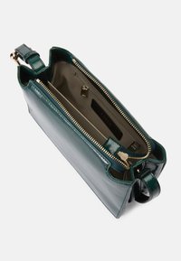 Bolsa de mão de couro verde com acabamento brilhante, fecho com zíper e compartimentos interiores. Apresenta acessórios em tom dourado e uma alça destacável.