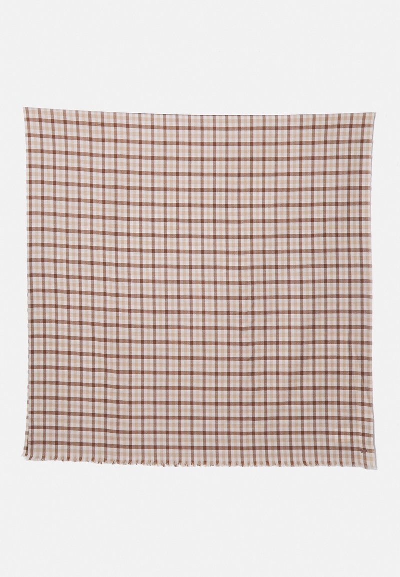 Tissu quadrillé beige et marron avec de fines bords effilochés, étalé à plat sur un fond blanc.