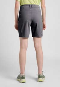 Graue Shorts aus leichtem Material mit glatter Textur, mittlerer Bundhöhe und zwei seitlichen Taschen. Kombiniert mit grünen Wanderschuhen.
