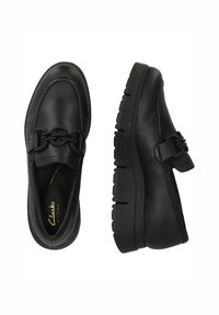 Svarta läderloafers med texturerad finish, som har en dekorativ kedjeaccent och tjocka gummisulor med mönster.