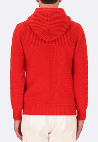 Hoodie rosso a maglia con un motivo testurizzato, dotato di cappuccio, polsini a coste e vita a coste. Il design è senza soluzione di continuità con dettagli di cucitura distintivi.