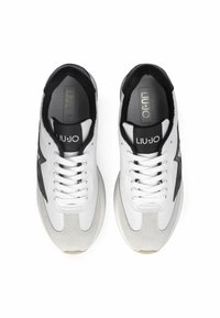 Sneaker bianche e nere con un upper in pelle liscia e suede, caratterizzate da una forma arrotondata, chiusura con lacci e dettagli con logo sulla linguetta.