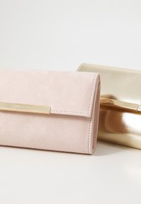 Two wallets: one in soft pink suede with a gold clasp, and another in metallic gold with a similar clasp detail.