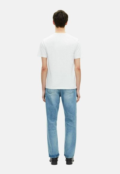 Witte korte mouwen t-shirt gecombineerd met lichtblauwe straight-leg jeans, met een klassieke pasvorm en minimale details, gezien van achteren.