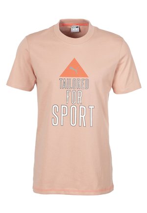 Světle růžové tričko s krátkým rukávem vyrobené z bavlny. Má klasický kulatý výstřih a grafický potisk s nápisem "USTANOVENO PRO SPORT" a trojúhelníkovým logem.