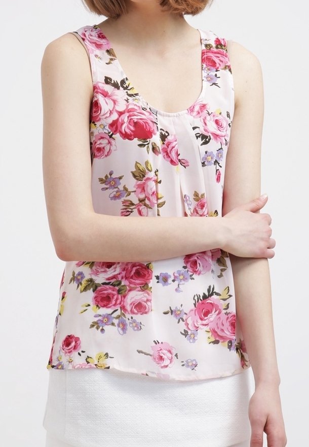 Top senza maniche floreale in tessuto rosa chiaro, con grandi rose e piccoli motivi floreali, scollatura tonda e vestibilità comoda.