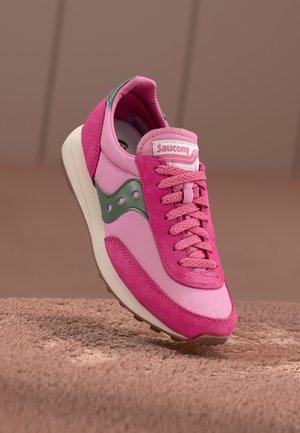 Roosa tossud, millel on sileda ja sametise tekstuuri kombinatsioon. Tootel on rohelised aktsendid, roosa pael ja valge tald. Saucony bränding keelel.