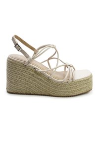 Witte wedge sandalen met gevlochten jute zool, gesloten neus en gedraaide details op de straps. Verstelbare enkelriem met gesp sluiting.