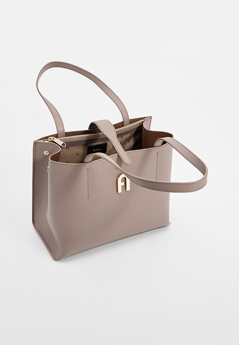 Beige Leder-Tragetasche mit goldfarbenen Beschlägen und zwei Henkel oben. Verfügt über einen Reißverschluss und eine Innentasche mit Logodetail.