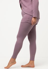 Leggings in lavanda, misto cotone, design aderente, texture liscia, lunghezza alla caviglia, con cuciture laterali e una finitura lucida discreta.