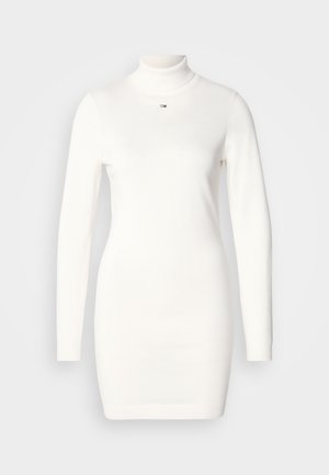 Abito bianco a maniche lunghe con colletto alto, realizzato in un tessuto a maglia liscia. Presenta una vestibilità slim e un piccolo logo sul petto.
