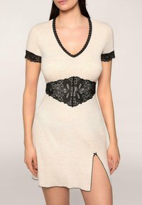 Sukienka dzianinowa w jasnym beżu z czarnym koronkowym wykończeniem na rękawach i w pasie, z ozdobnym koronkowym paskiem i bocznym rozcięciem u dołu.