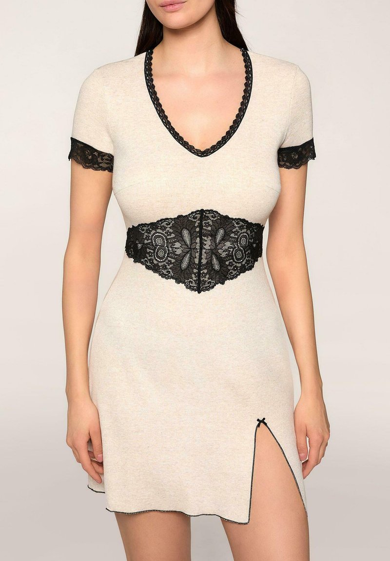Sukienka dzianinowa w jasnym beżu z czarnym koronkowym wykończeniem na rękawach i w pasie, z ozdobnym koronkowym paskiem i bocznym rozcięciem u dołu.