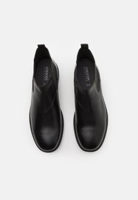 Μαύρες δερμάτινες μπότες αστραγάλου με λεία υφή, σχέδιο για εύκολη σφήνα, στρογγυλές μύτες και μικρές λαβές στα τακούνια. Ορατό λογότυπο Geox στο εσωτερικό.