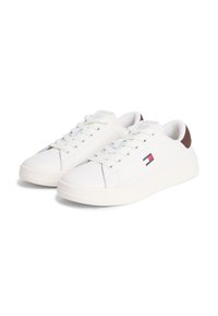 Λευκά αθλητικά παπούτσια από λείο συνθετικό υλικό με καφέ λεπτομέρειες στη φτέρνα, διαθέτουν κλείσιμο με κορδόνια και λογότυπο στο πλάι.