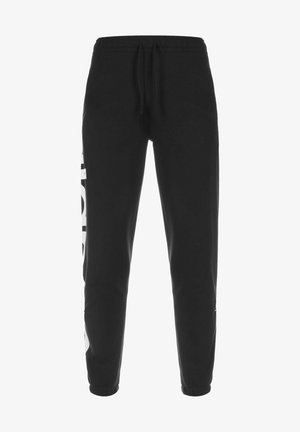 Pantaloni della tuta neri realizzati in un tessuto morbido, con una vestibilità affusolata, vita elastica con cordoncino e un grande logo bianco sul lato sinistro.