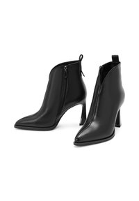 Bottines en cuir noir avec bouts pointus, fermetures éclair latérales, talons carrés hauts et languettes à l'arrière.