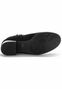 Bottine en suede noir avec un talon carré et une semelle en caoutchouc texturée. Dispose d'une fermeture éclair sur le côté et d'un intérieur doux pour le confort.