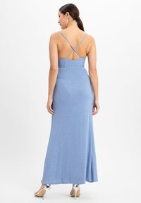 Funkelndes blaues Maxikleid mit einem taillierten Oberteil, über Kreuz verlaufenden Trägern am Rücken und einem schwingenden Rock. Die glatte Textur verstärkt den Gesamtschimmer.