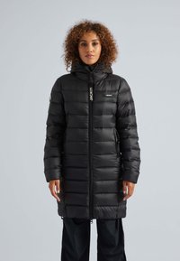 Piumino nero con cappuccio, dotato di zip frontale, tasche laterali e texture trapuntata. Etichetta del marchio "JACKIT" sul petto.